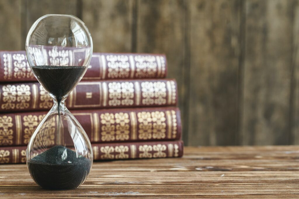 Vintage hourglass against a stack of old books