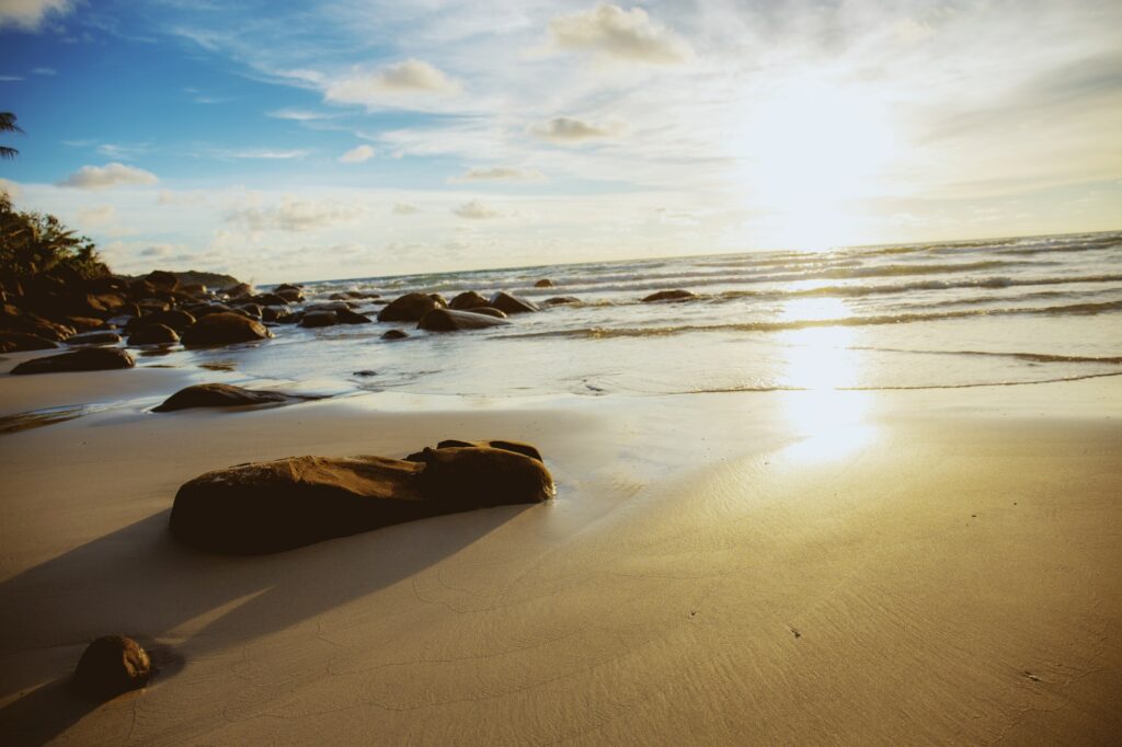 Rocks on sand beach with sunrise